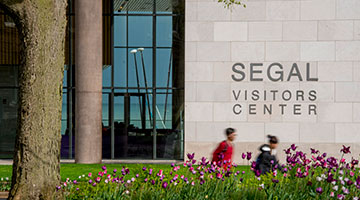 People walking in front of the Segal Visitors Center on campus